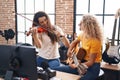 Two women musicians playing violin and classical guitar at music studio Royalty Free Stock Photo