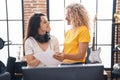 Two women musicians reading music sheet at music studio Royalty Free Stock Photo