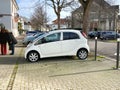 Two women near the white Peugeot mini car