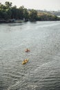 Two women and one man kayaking in the river at summer morning. Back view