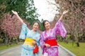Two women open arms with cherry-blossom