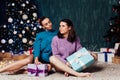 Two women open gifts at the Christmas tree for the new year