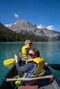 Two women paddling on a canoe turn around and smile, while boating on Emerald Lake in Canada Royalty Free Stock Photo