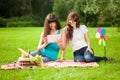 Two women in the park on a picnic with a Tablet PC Royalty Free Stock Photo