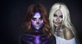 Two women portrait creative halloween makeup sugar skull style painted with white black purple paints on woman face Royalty Free Stock Photo