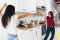 Two woman prepare food play in kitchen