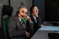 Two women in protective masks are bored at work. Call center operators at the desk Royalty Free Stock Photo