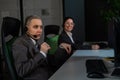 Two women in protective masks are bored at work. Call center operators at the desk Royalty Free Stock Photo