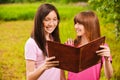 Two women read a book