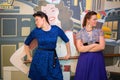 Two women in retro-style dresses looking in