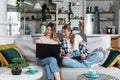Two women, roommates and business partners, jot down and steal business ideas from the internet about what they can do with their
