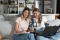 Two women, roommates and business partners, jot down and steal business ideas from the internet about what they can do with their