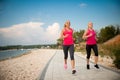 Two women athlets running on the beach - early morning summer w Royalty Free Stock Photo