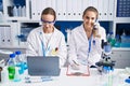 Two women scientists talking on the smartphone working at laboratory