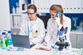 Two women scientists talking on the smartphone working at laboratory