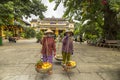 Two women selling fruit in the streets of Hoi An