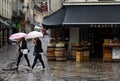 Two women with shopping bags ounder umbrellas