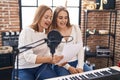 Two women singers singing song at music studio Royalty Free Stock Photo