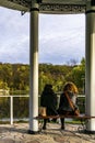 Two women sit dreamly looking on the pond in the city park Royalty Free Stock Photo