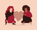 Two women sit and hold a big heart and looks happy. Girls with different ethnicity support each other. Love Yourself concept