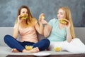 Two women sitting at coach eating fast food Royalty Free Stock Photo