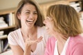 Two women sitting in living room talking and laugh Royalty Free Stock Photo