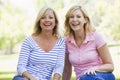 Two women sitting outdoors smiling Royalty Free Stock Photo