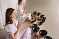 Two women are sitting with Tibetan bowls in the lotus position before a yoga class in the gym Royalty Free Stock Photo