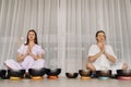 Two women are sitting with Tibetan bowls in the lotus position before a yoga class in the gym Royalty Free Stock Photo