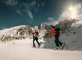 Two women ski walkers go up on the mountain top.