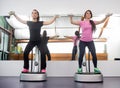 Two women standing exercise weights, fitness equipment similar t