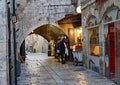 Two women stop at a refreshment stand in a narrow cobblestoned lane of the Old City of Jerusalem