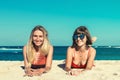 Two women sunbathing lying down on the tropical beach summer travel holidays. Bali island. Royalty Free Stock Photo