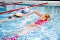 Two women swimmer swim in a contest to win the indoor sports poo