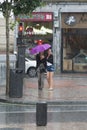 Two women take shelter in a tiny umbrella
