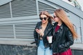 Two Women Talking in the City.Outdoor lifestyle portrait of two best friends hipster girls wearing stylish Leather Royalty Free Stock Photo