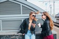 Two Women Talking in the City.Outdoor lifestyle portrait of two best friends hipster girls wearing stylish Leather Royalty Free Stock Photo