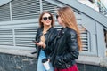 Two Women Talking in the City.Outdoor lifestyle portrait of two best friends hipster girls wearing stylish Leather Royalty Free Stock Photo