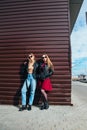 Two Women Talking in the City.Outdoor lifestyle portrait of two best friends hipster girls wearing stylish Leather Royalty Free Stock Photo