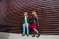 Two Women Talking in the City.Outdoor lifestyle portrait of two best friends hipster girls wearing stylish Leather Royalty Free Stock Photo