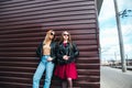 Two Women Talking in the City.Outdoor lifestyle portrait of two best friends hipster girls wearing stylish Leather Royalty Free Stock Photo