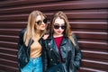 Two Women Talking in the City.Outdoor lifestyle portrait of two best friends hipster girls wearing stylish Leather Royalty Free Stock Photo