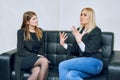 Two women are talking on the sofa