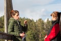 Two women are talking to each other while on a wooden bridge Royalty Free Stock Photo