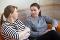 Two women talking together while sitting sofa indoor Royalty Free Stock Photo