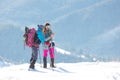 Two women on top of a mountain are checking navigation on a smartphone