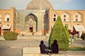 Two women in traditional hijab meeting near historical mosque Masjed-e Sheikh Lotfollah in Isfahan.