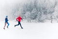 Two women trail running on snow in winter mountains Royalty Free Stock Photo