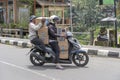 Two women is transporting goods on a motorbike on a street in Ubud, island Bali, Indonesia, close up