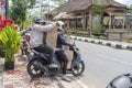 Two women is transporting goods on a motorbike on a street in Ubud, island Bali, Indonesia, close up